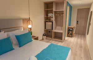 波哥大Hotel Fontana Bogotá的一间卧室配有一张带蓝色枕头的大床