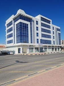 Al Fayşalīyahفندق روزميلون的一座大型建筑,前面设有停车场