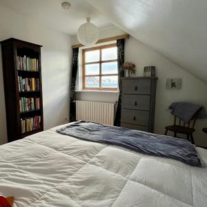 BíldudalurGuesthouse at Dynjandi Falls的卧室配有白色的床和窗户。