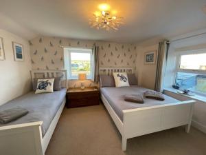 圣提斯Sandown 4 bedroom house St Teath的一间卧室配有两张床和吊灯。