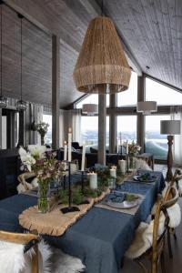 LjørdalLuxurious Mountain Lodge的用餐室配有带鲜花和蜡烛的蓝色桌子