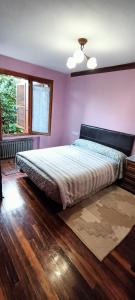 希洪Chalet céntrico/costero en Gijón的一间卧室设有一张紫色墙壁的大床