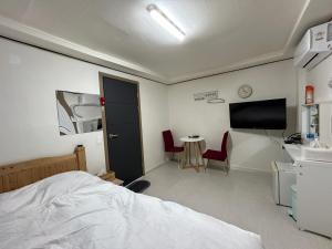木浦市369 Motel的一间卧室配有一张床、一台电视和一张桌子