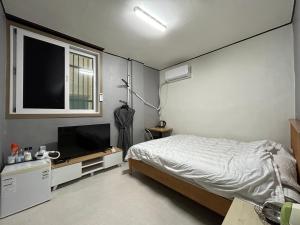 木浦市369 Motel的一间卧室配有一张床和一台平面电视