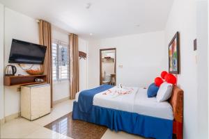 顺化阿莫纳酒店的一间卧室配有一张床和一台平面电视