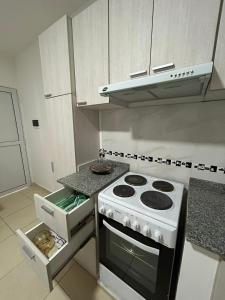 雷西斯膝西亚Edificio Misionero Klein的厨房配有白色炉灶和微波炉