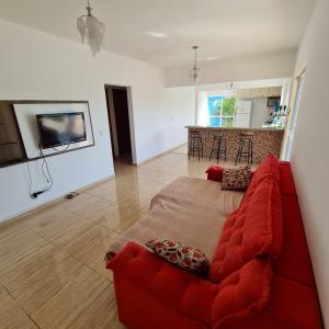 PorangabaCasa em condomínio Ninho Verde 1的一间带红色沙发的客厅和一间厨房
