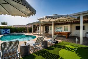 百慕大沙丘La Reina Inn Swim Club的一个带椅子、游泳池和桌子的庭院