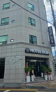 木浦市Hotel Bom的前面有盆栽植物的酒店大楼