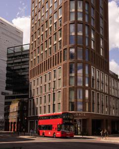 伦敦The Gate ApartHotel London的停在大楼前的红色双层公车