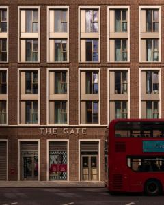 伦敦The Gate ApartHotel London的停在大楼前的红色双层公车