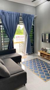 丹那美拉Homestay Mohd Aizri Bukit Gading的带沙发和蓝色窗帘的客厅