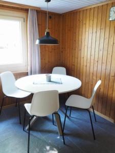 迈林根Appartement Gmeindmatte的一间配备有白色桌椅的用餐室