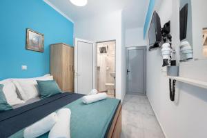 卡尔扎迈纳Lefteris Apartment的一间拥有蓝色墙壁的卧室、一张床和一间浴室
