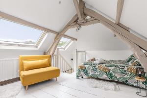 鲁昂Maison individuelle dans ancienne ecurie的一间卧室配有一张床和一张黄色椅子