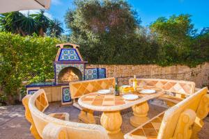 拉坎努塔Villa Sanlio - PlusHolidays的庭院配有桌椅和壁炉。
