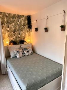 滨海卡涅Orangers - Bord de mer-Studio cosy refait à neuf 4 personnes的墙上植物的房间的一张床位