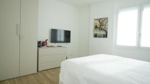 帕多瓦Palazzo Gilberto的一间白色卧室,配有床和电视