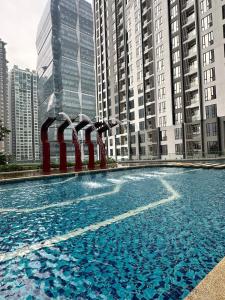 吉隆坡Sentral Luxury Suites KL的一座蓝色的大游泳池,位于高楼前