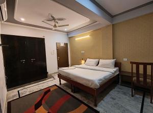 斋浦尔Hotel 7 Nights Jaipur的一间卧室配有一张床和吊扇