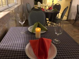 基多Apricot Hosteria的一张桌子,上面有两个盘子,一个蜡烛和玻璃杯
