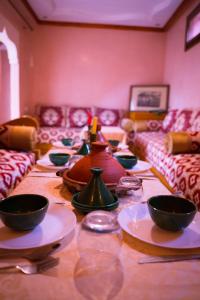 马拉喀什RIAD LAICHI的一张长桌,上面有碗和盘子