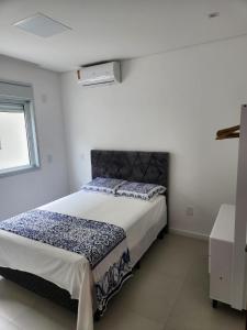 帕罗卡Recanto Brisa e Mar的一间白色客房内配有一张大床的卧室