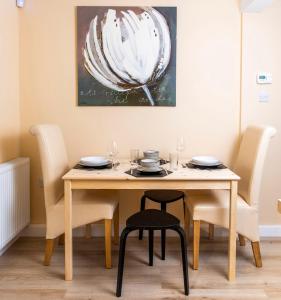LochwinnochThe Apartment at No.12的餐桌和椅子,墙上有绘画作品