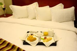 雅温得拉法赖斯雅温得酒店的一张床上放着食物的托盘