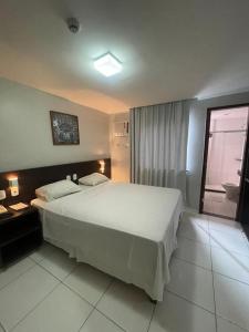 萨尔瓦多阿布索路特酒店的卧室设有一张白色大床和一扇窗户。