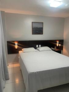 萨尔瓦多阿布索路特酒店的卧室配有一张白色大床和两个灯