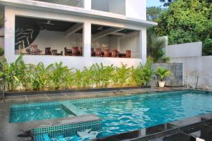 坎多林Premium 2BHK Apartment with pool at Candolim Beach的房屋前有游泳池的房子