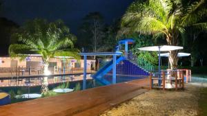 科隆Hacienda Alajuela的一个带滑梯和夜间游泳池的度假村
