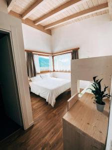 卡尔多纳佐AGRITURISMO DAL PEROTIN的一间大卧室,配有一张床和一个大窗户