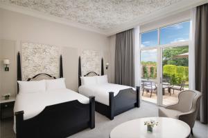 温莎Fairmont Windsor Park的酒店客房设有两张床和一张桌子。