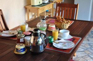 Villefranche-Sur-CherLa Petite Tuilerie的一张木桌,上面摆放着早餐食品和饮料