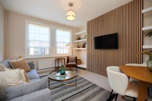 伦敦The Elmington Estate Place - Elegant 1BDR Flat的客厅配有沙发和墙上的电视