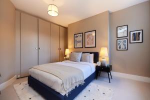伦敦The Elmington Estate Place - Elegant 1BDR Flat的一间卧室配有一张大床和两盏灯。