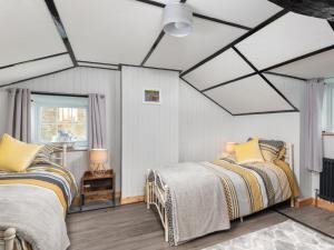Mawbray2 bed property in Mawbray Cumbria SZ214的一间卧室设有两张床和天窗天花板。