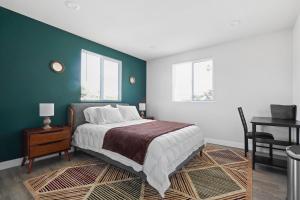 洛杉矶Good Shepard Homestay的一间卧室配有一张床、一张书桌和两个窗户。