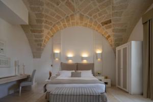 奥特朗托Baglioni Masseria Muzza的一间卧室设有一张带石质天花板的大床