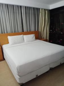 吉隆坡BBS APARTMENT AT TIMES SQUARE KUALA LUMPUR MALAYSIA的卧室内的一张带白色床单和枕头的床