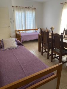圣罗莎Complejo Pampa 1的一间卧室配有两张床和一张桌子及椅子