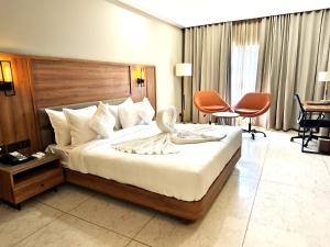 贾姆讷格尔The Sky Imperial Hotel Kailash的酒店客房,配有一张床、一张桌子和椅子
