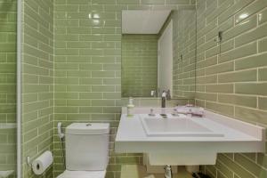 圣保罗Charlie NUN Itaim的绿色瓷砖浴室设有水槽和卫生间