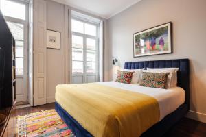 波尔图Utopian Hotel, a charming guesthouse的一间卧室配有一张带黄色毯子的大床