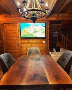 地拉那DAJTI PARADISE RESORT的一间带大木桌和电视的用餐室