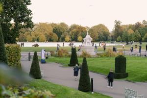 伦敦Sonder Kensington Gardens的一群人在一个喷泉公园里散步