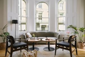伦敦Sonder Kensington Gardens的客厅配有沙发和2张桌子及椅子