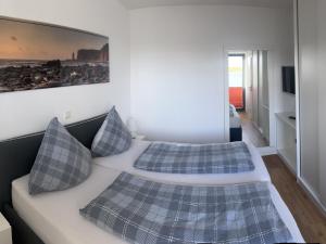 黑尔戈兰岛Tor zum Meer的一间卧室配有两张带蓝色格子枕头的床
